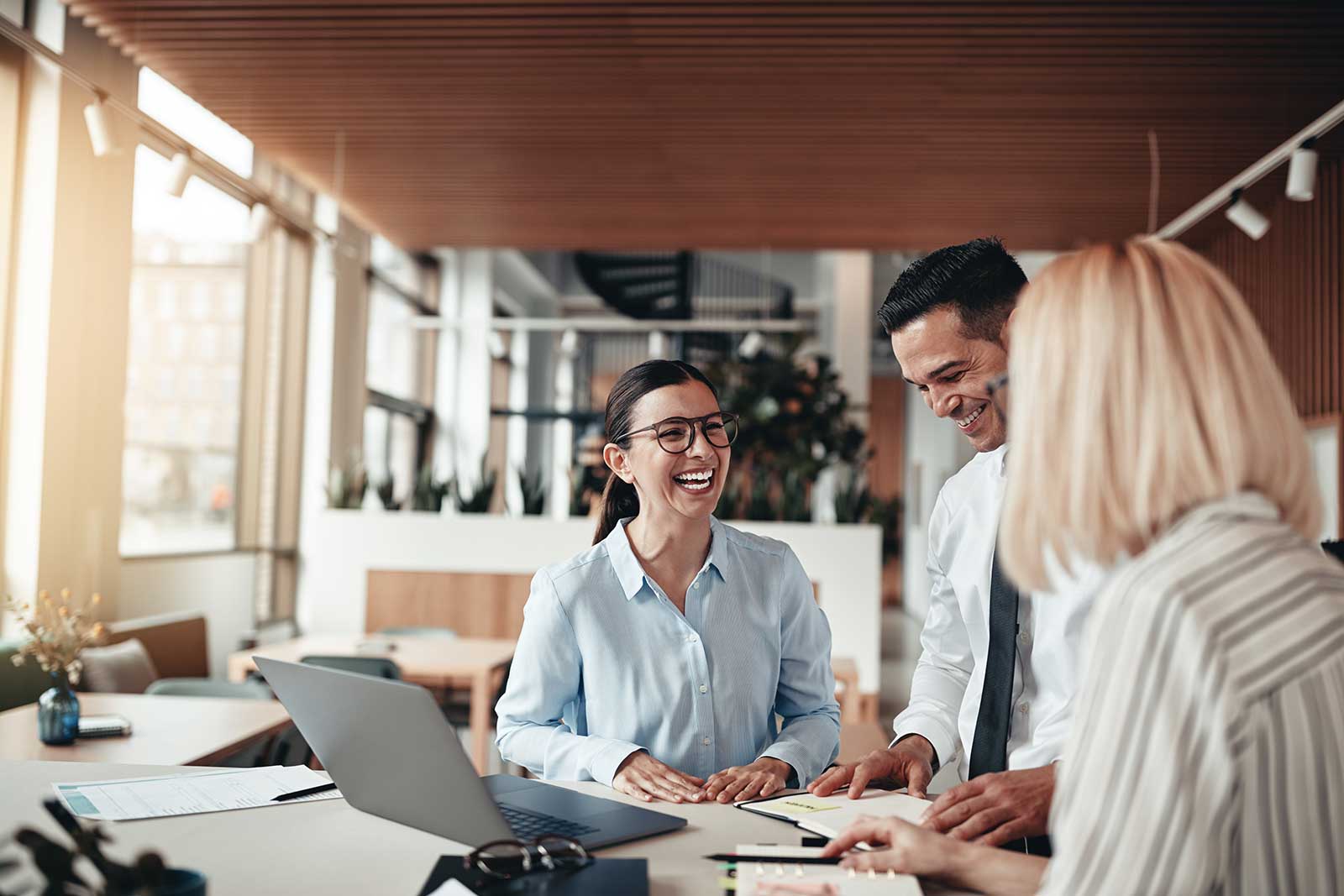 Certified accountants smiling at office while filing 1040 and 1099 forms