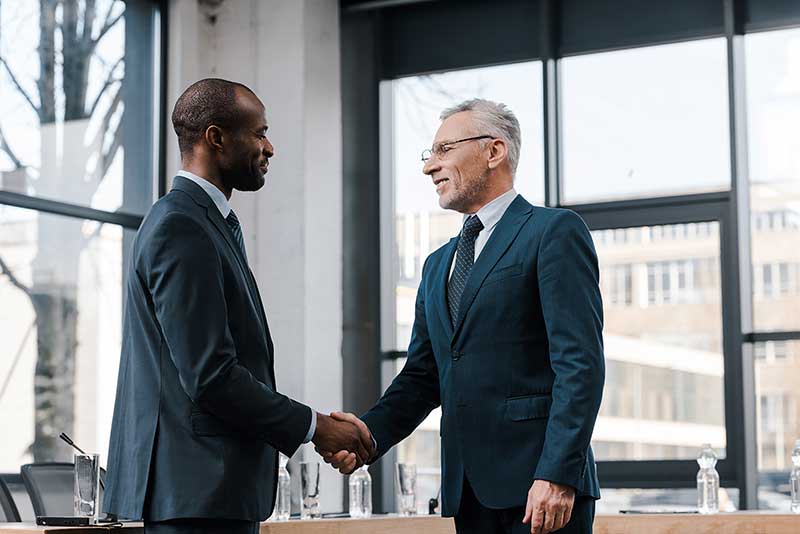 Executive partners shaking hands after filing their partnership tax returns