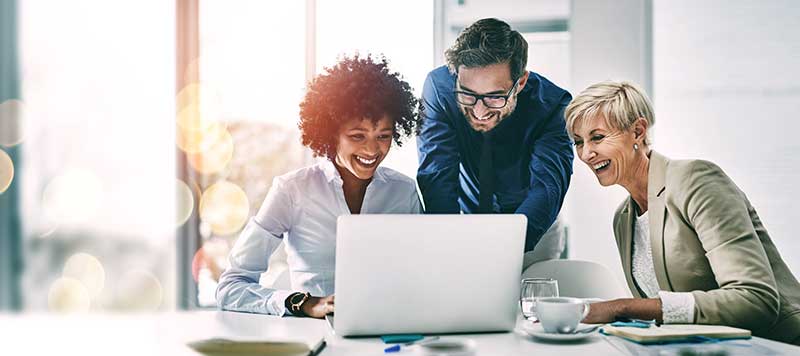 Professional accountants huddled around computer