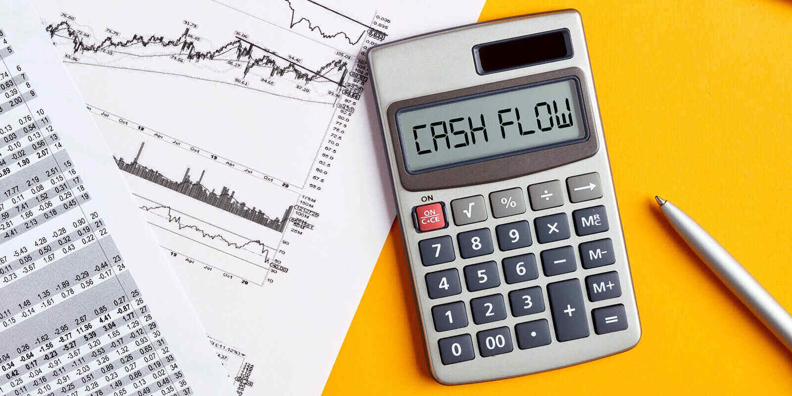 word cash flow on calculator display screen with business office desktop