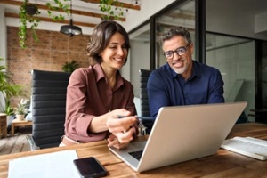 business team of two executives working together using laptop in office