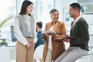 happy or funny business people in meeting laughing at joke in discussion with paperwork