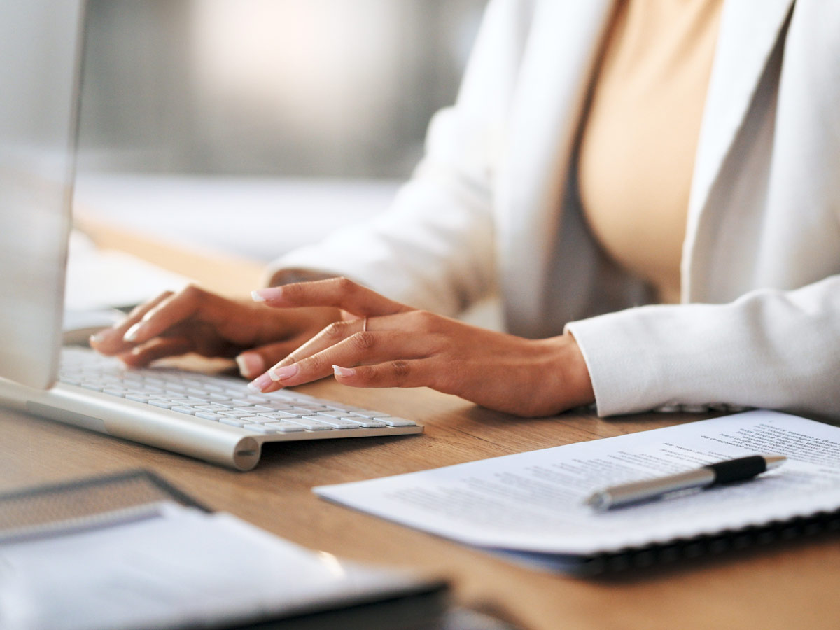 women typing on computer at work