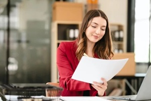 an accountant or CPA, smiling and holding a coffee cup while working on her laptop before switching payroll companies