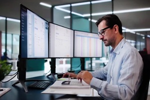 man working on miltiple computers