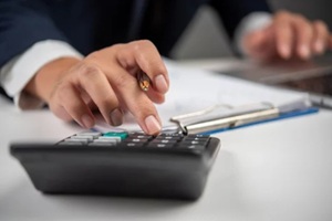 women hand using calculator before switching payroll companies